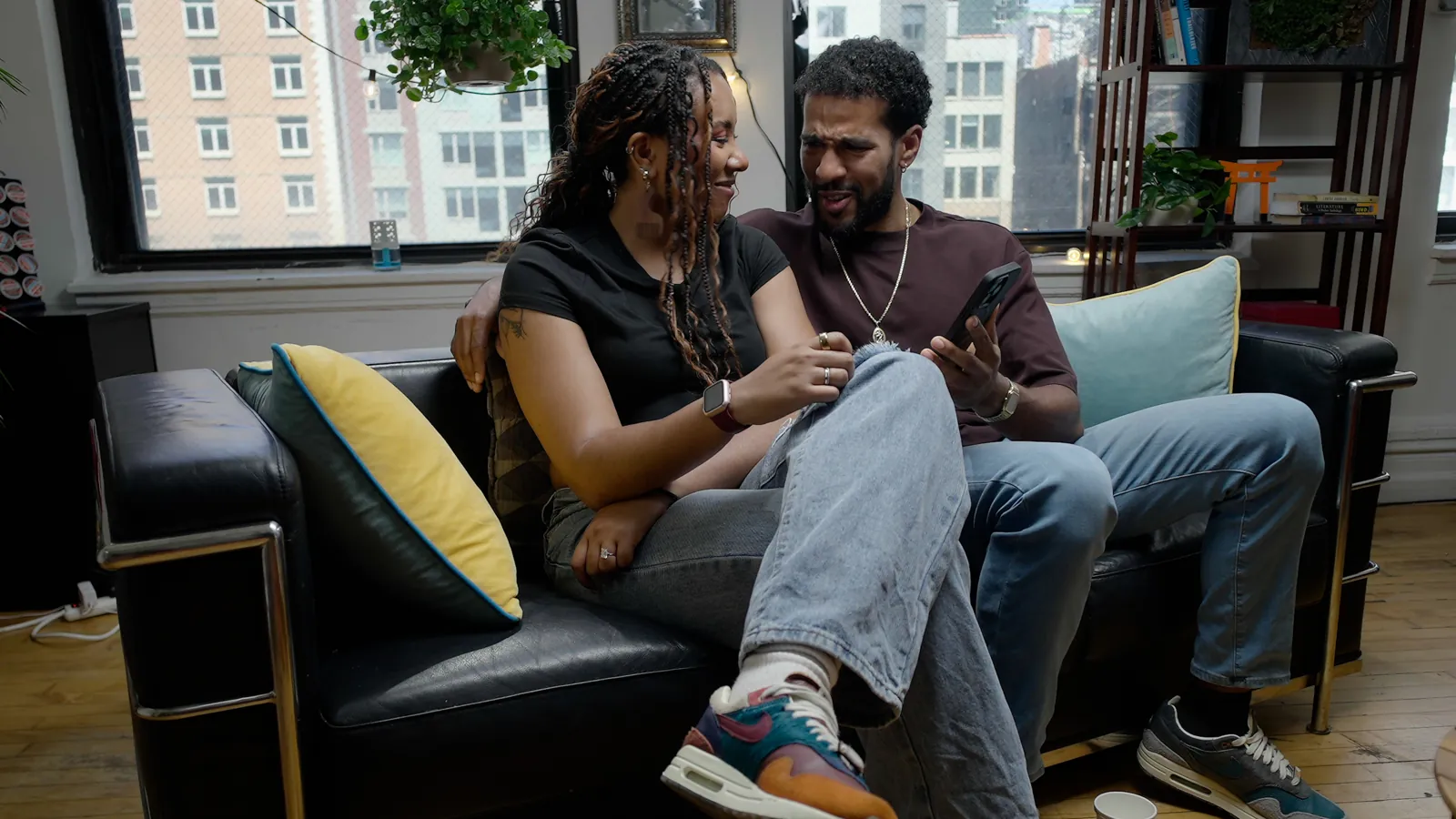 A couple laughing together on the AL: The Show couch