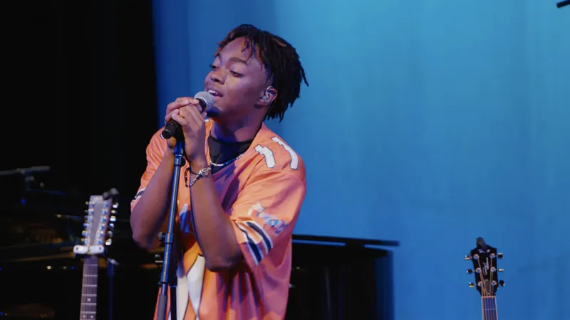 A singer performing at a microphone, framed for a social clip