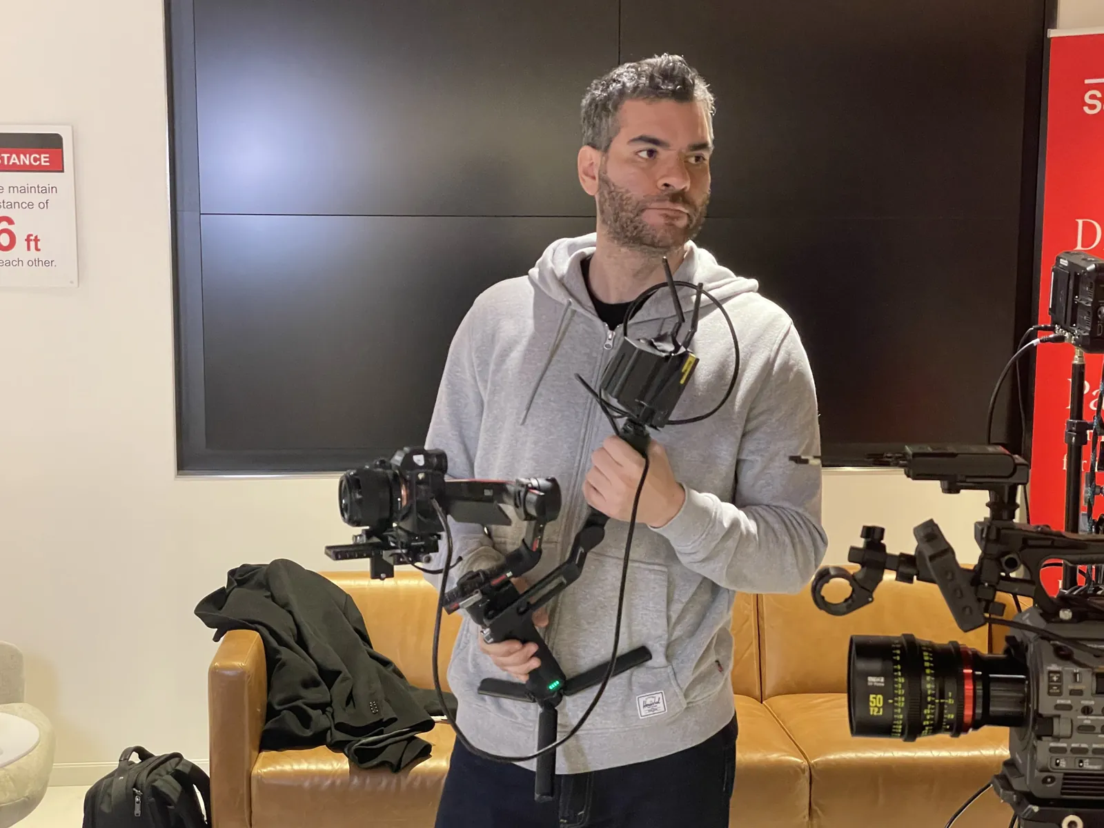 A camera operator holding a gimbal rig in an office before a shoot