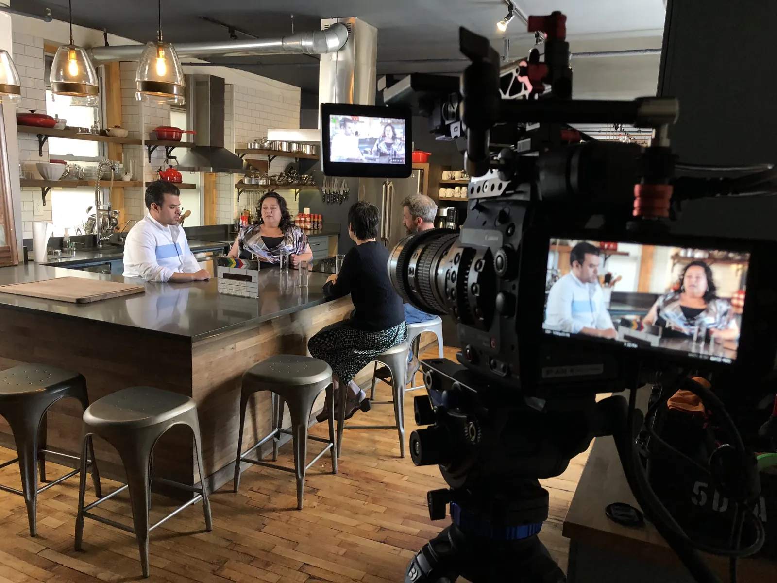 The Transcendent crew filming a conversation at a restaurant bar