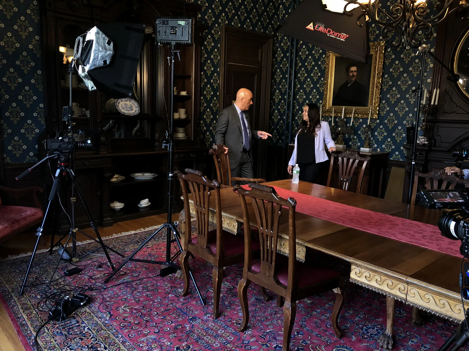 A full lighting and camera setup for an interview in a wood-paneled boardroom