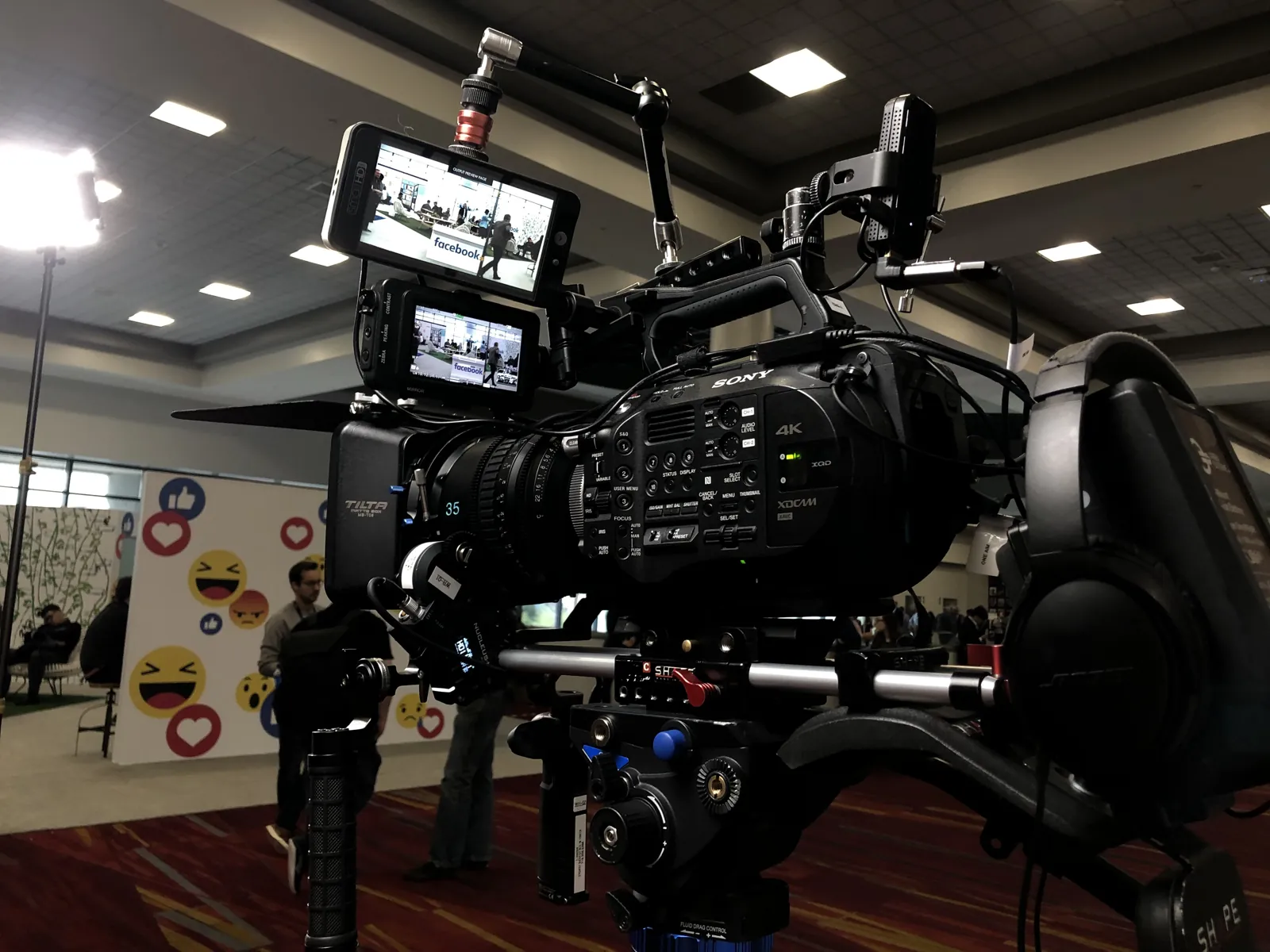 A rigged cinema camera on a tripod ready to roll on a conference floor