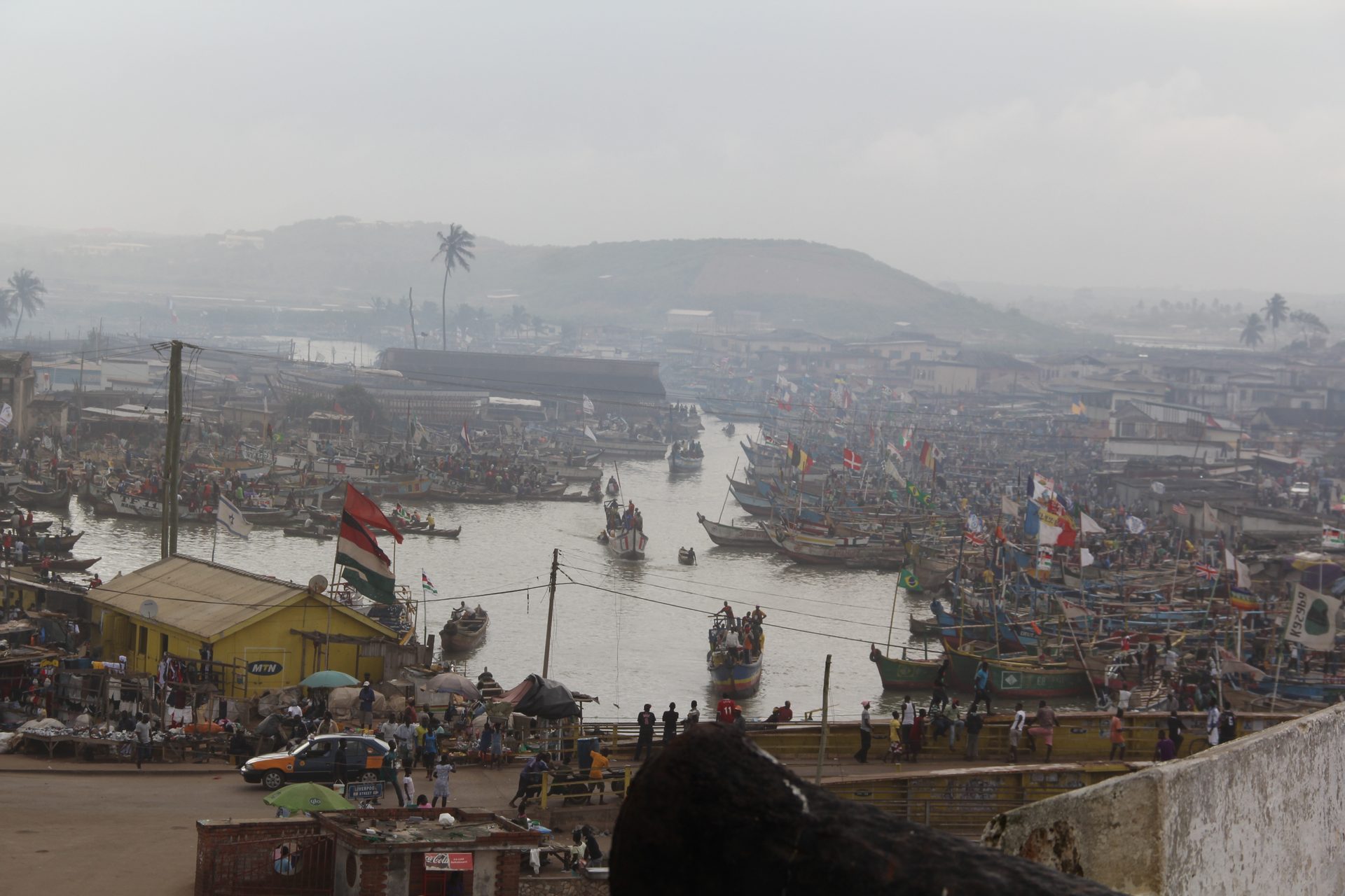 Fishing harbor in Ghana filled with flag-flying boats — filmed on location by Transcendent Enterprise