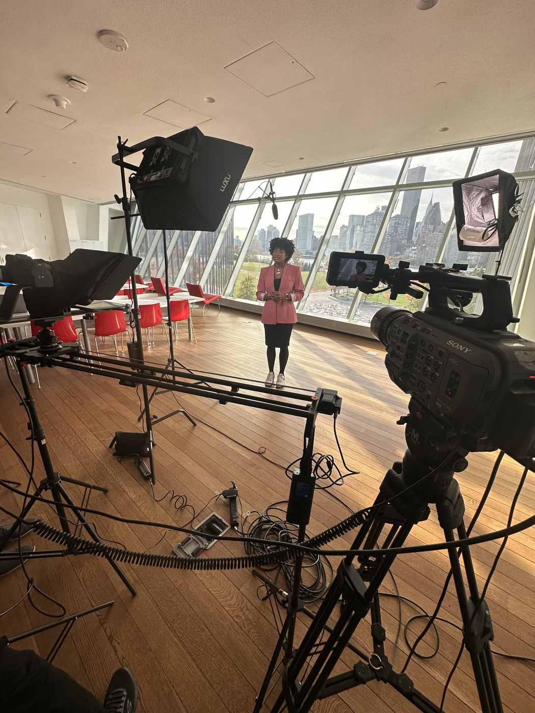 Executive video setup with camera slider, teleprompter, and skyline backdrop at a university campus