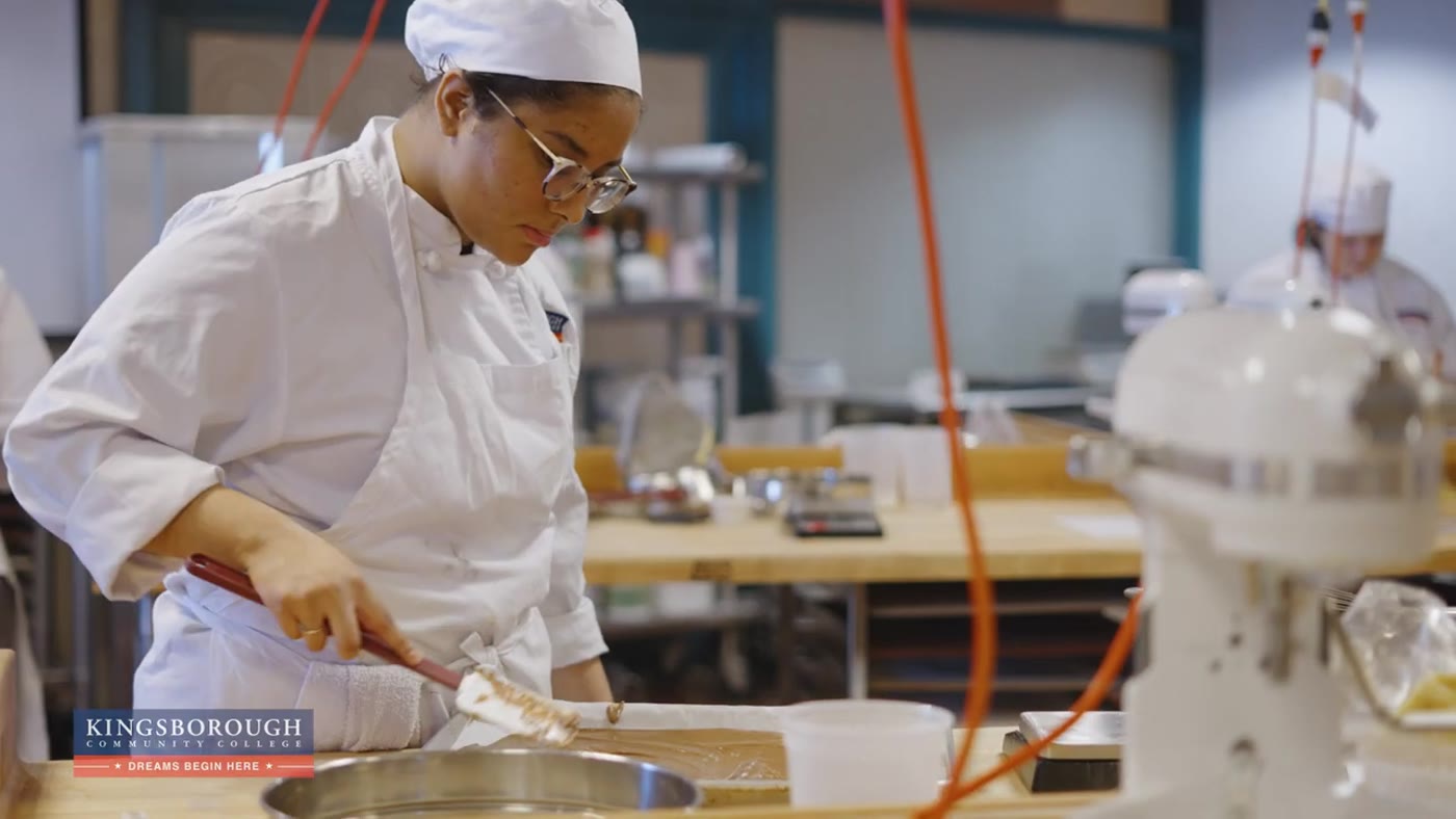Culinary Arts student in chef whites from the Kingsborough Community College campaign