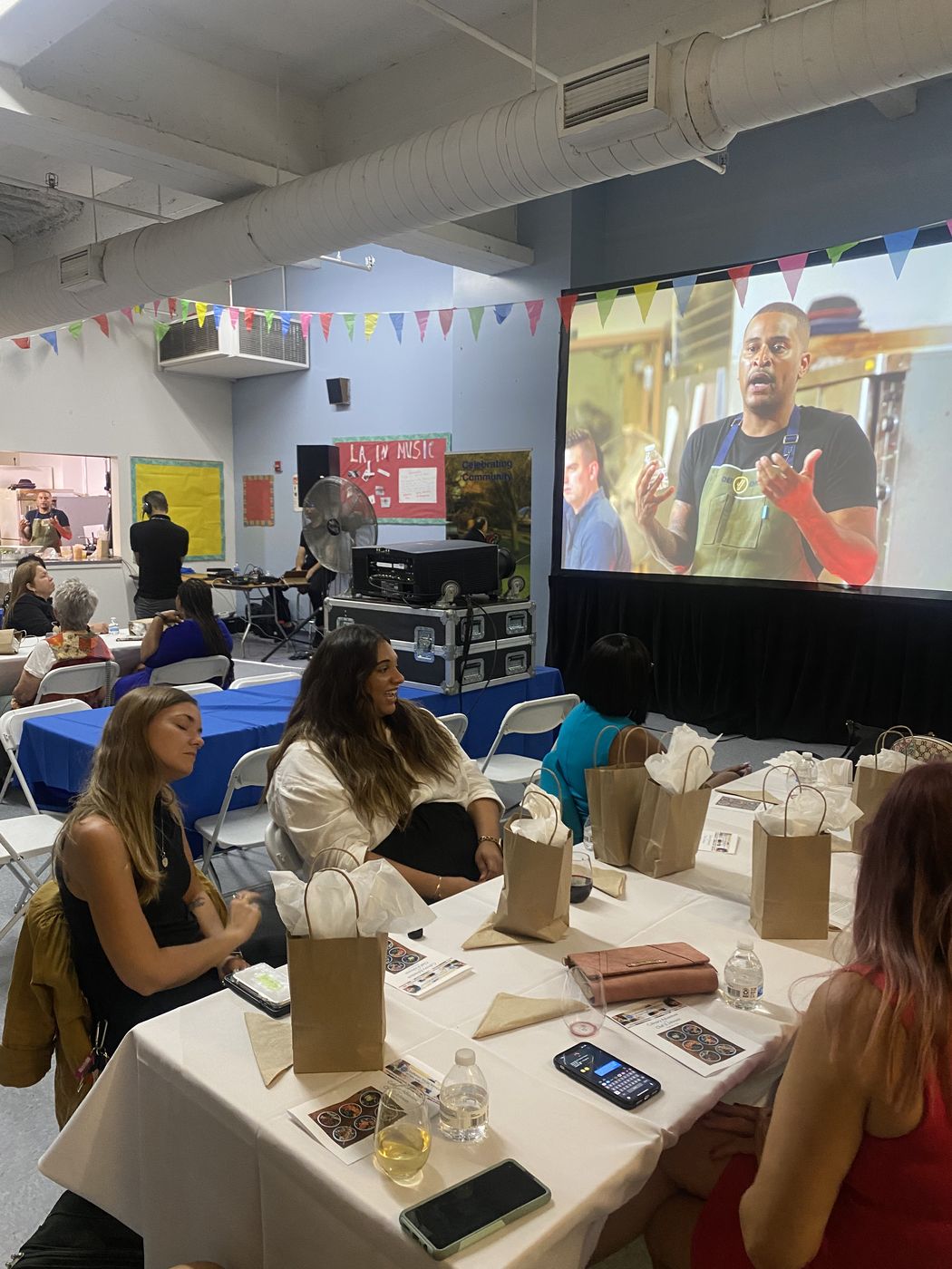 Hybrid event with a remote speaker on screen presenting to an in-person audience in NYC