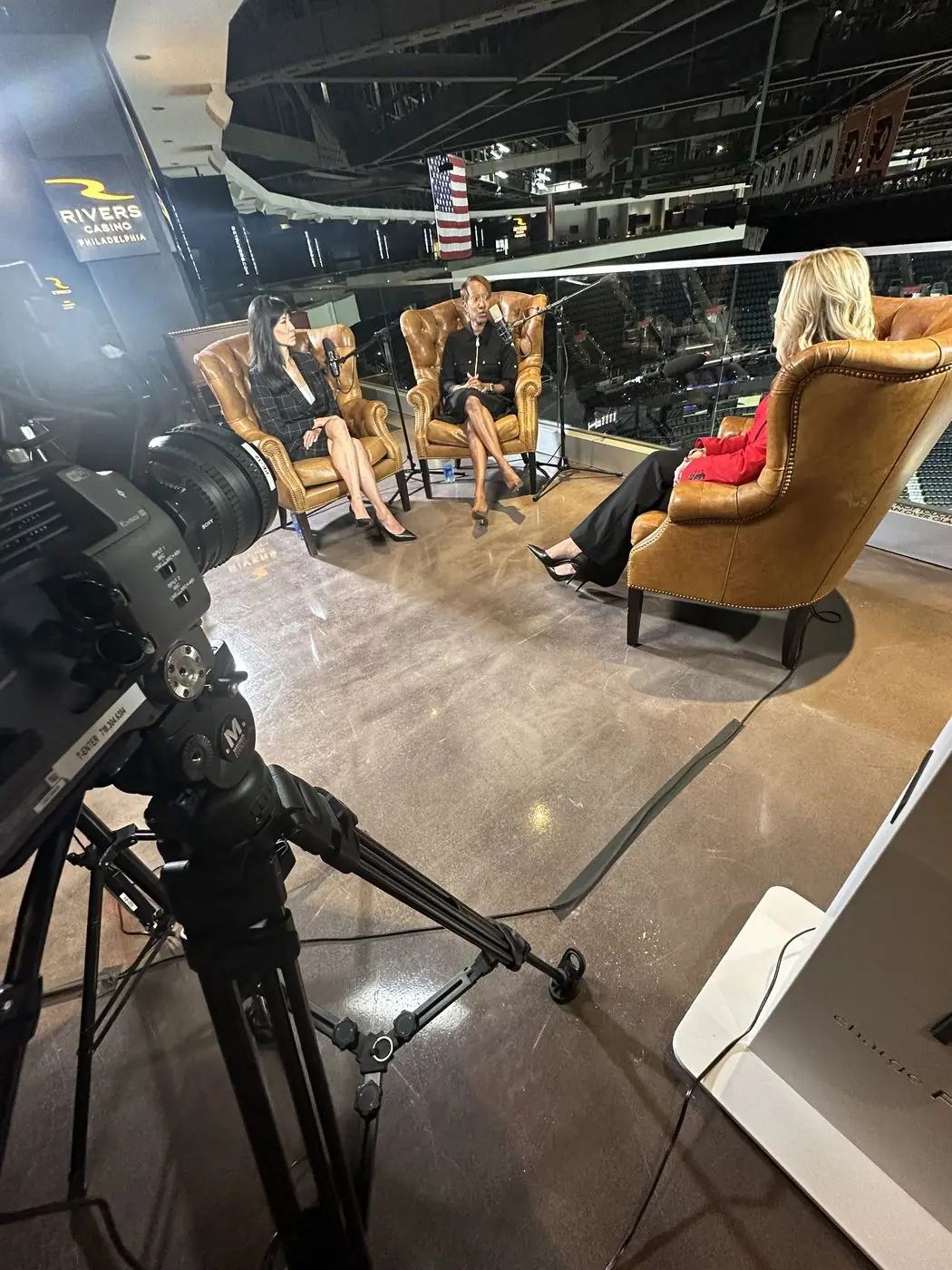 Multi-camera podcast set with leather chairs built overlooking an arena floor