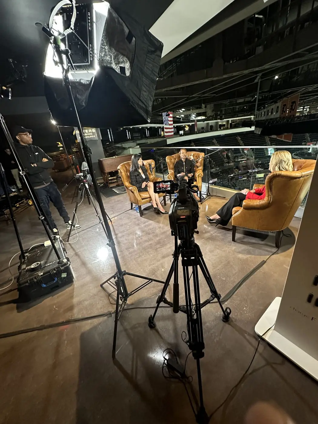 Cameras and lighting rigged for an on-location podcast recording at an arena