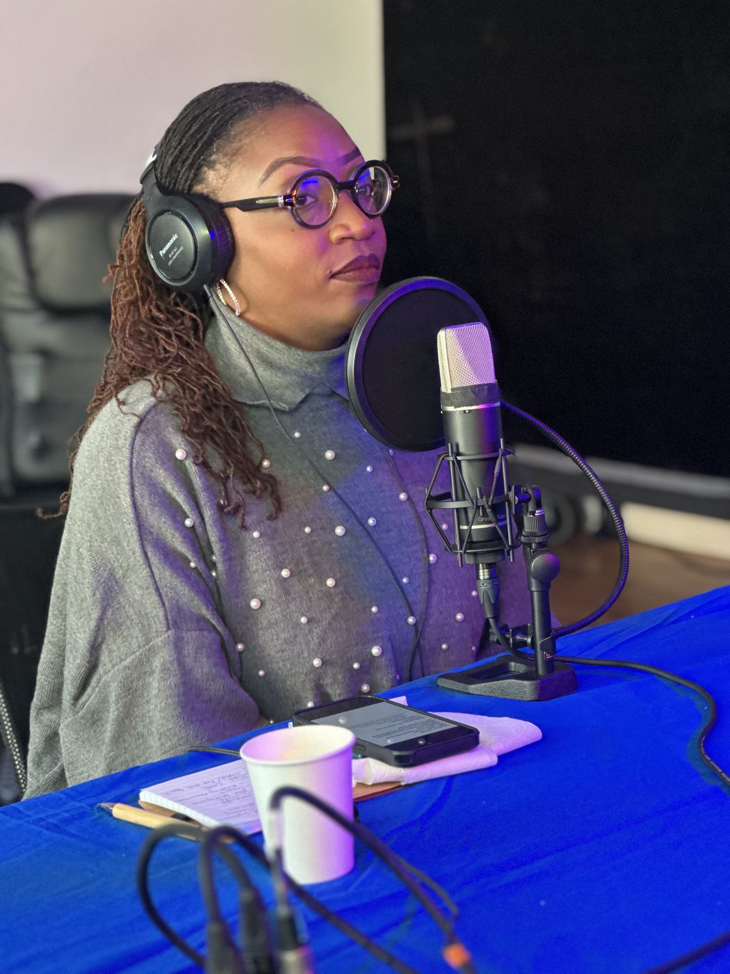Guest recording a podcast episode with professional microphone and headphones