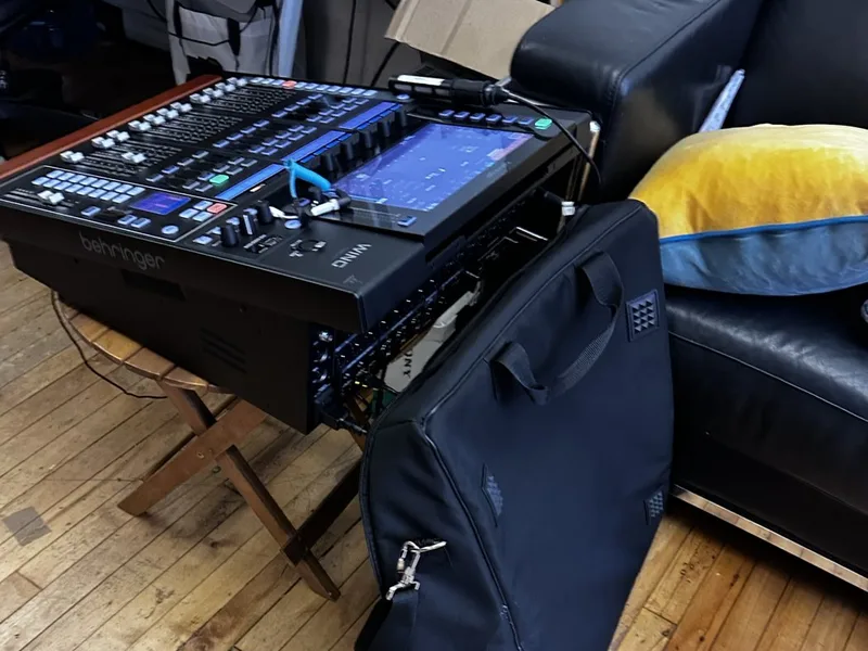 A Behringer WING digital mixing console with its touchscreen and faders, set up in the studio
