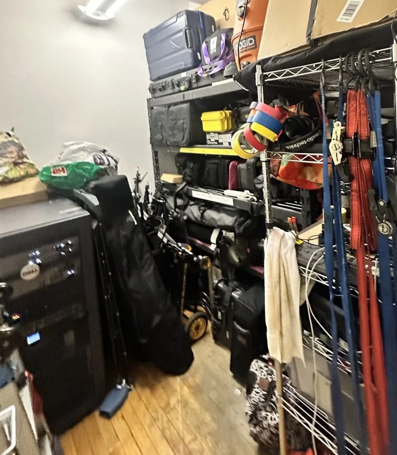 The studio gear room with the server rack, cased equipment and stands on shelves