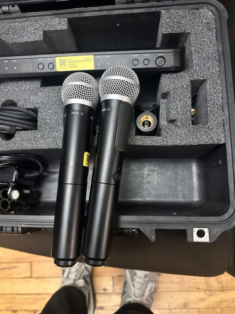 Two Shure wireless handheld microphones and a receiver in a foam-lined case